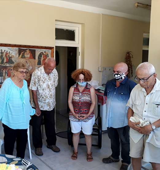 Foto de la Rev. Ofelia Ortega orando con amigos en la terraza de su casa